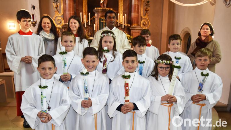 Die neun Erstkommunionkinder mit den Ministranten, Pfarrvikar Thomas Sannikommula (Mitte), der Hauptorganisatorin der außerschulischen Vorbereitung, Isabel Riederer von Paar (rechts), und Helferin Silke Steinmetz (Zweite von links). Bild: no