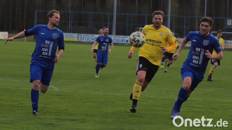 Die Etzenrichter Andreas Wendl (links) und Oliver Danzer (rechts) schirmen Manuel Plach vom SV Hahnbach ab. Bild: war