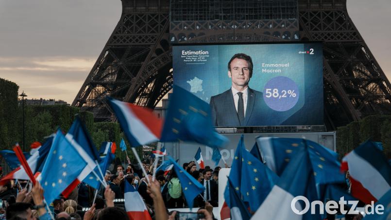 Sonntagabend in Paris: Emmanuel Macron, Präsident von Frankreich, ist auf einem Bildschirm vor dem Eiffelturm zu sehen, als die ersten Wahlprognosen bekannt gegeben werden. Wie haben französische Kommunen gewählt, die partnerschaftlich mit Städten im Landkreis Schwandorf verbunden sind? Bild: Christophe Ena/dpa