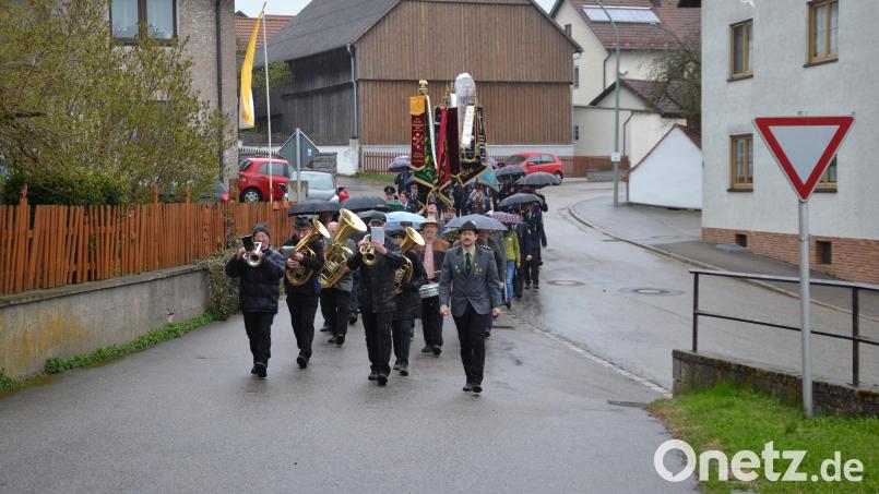 Die Vereinsdelegationen machen sich mit ihren Fahnen auf den Weg zur Kirche. Bild: gi