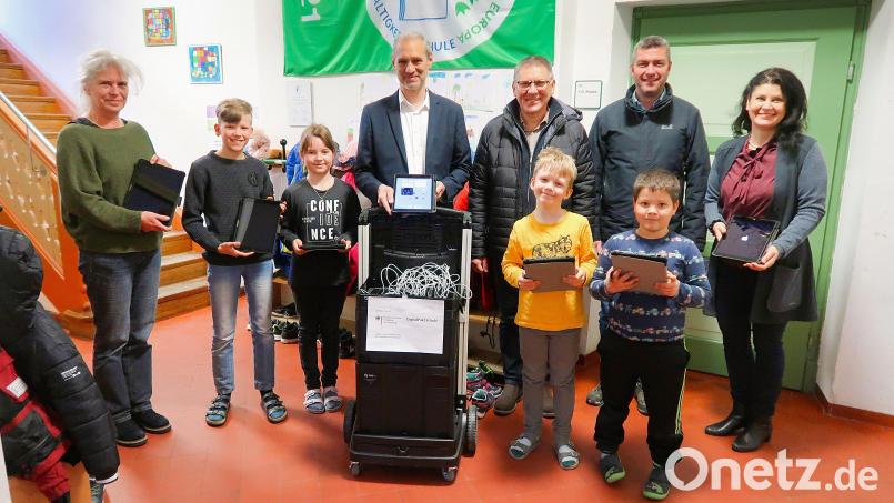 Bei einer kleinen Feierstunde an der Grundschule Friedenfels übergab Schulleiterin Inge Dick (rechts) im Beisein einiger Kinder 20 Tablets an das Lehrpersonal, vertreten durch Claudia Wölke und Stefan Müllbauer (von links). An Bürgermeister Oskar Schuster (Dritter von rechts) und Bernhard Schmidt (Zweiter von rechts) von der Gemeindeverwaltung gingen Dankesworte für ihr Engagement bei der Beschaffung der Geräte. Bild: bsc