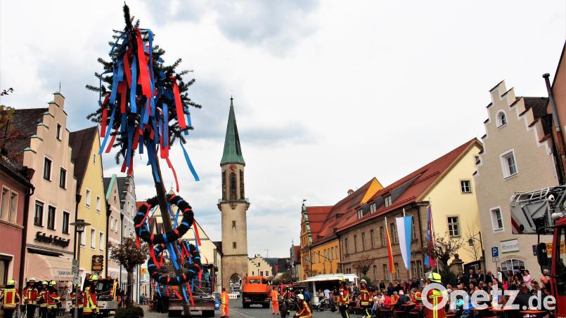 Mitglieder der Feuerwehren Kemnath und Kötzersdorf sicherten den Kemnather Maibaum ab, während ein Bagger den Stamm in die Senkrechte zog. Bild: stg