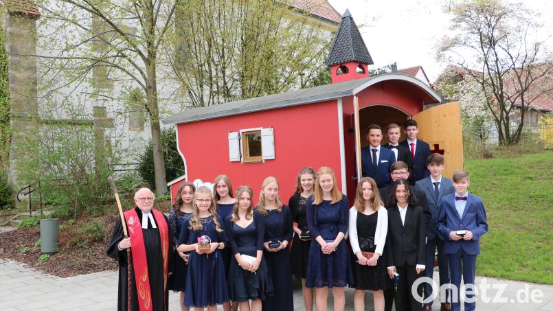 Die Mädchen und Jungen nach ihrer Konfirmation mit Pfarr Matthias Ahnert vor der Schäferwagenkirche am Kirchplatz in Edelsfeld. Bild: gru