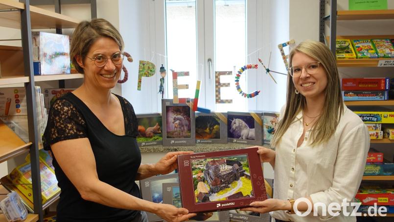 Nina Lenfers (rechts) und Doris Neumann (links) zeigen eines der neuen Puzzles in der Parksteiner Bücherei. Bild: adj