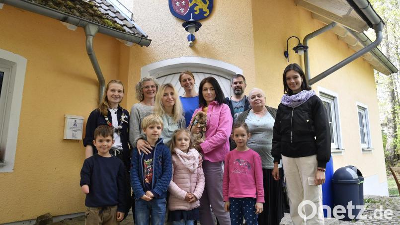 Leonie und Angela Kopczyk, Nicole Glück und Lars Pachmann (hintere Reihe, von links) haben ihr Pfadfinderheim zur Familienwohnung umgebaut. Ihre Kinder Leo und Lisa (vordere Reihe, Erster und Vierte von links) spielen gerne mit ihren neuen Freunden aus der Ukraine. Myroslav, Alina, Kateryna, Nadiia, Oma Nadiia und Anastasiia sind froh, dort eine sichere Bleibe gefunden zu haben. Bild: Petra Hartl