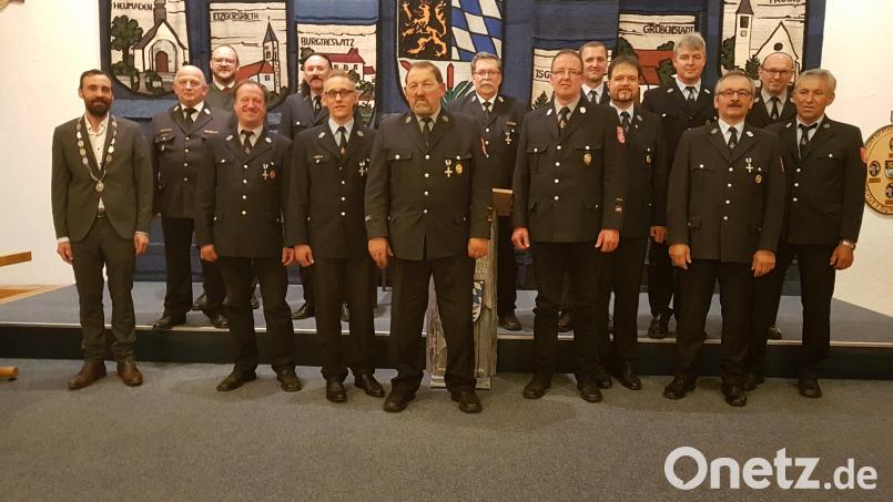 Landrat Andreas Meier (Dritter von links) ehrte 18 Feuerwehrmänner für 25- bzw. 40-jährige ehrenamtliche Dienstzeit aus sechs von zehn Feuerwehren der Marktgemeinde Moosbach. Bürgermeister Armin Bulenda (links), Kreisbrandinspektor Martin Weig (Zweiter von links) und Kreisbrandmeister Thomas Kleber (Achter von links) gratulierten. Bild: gi