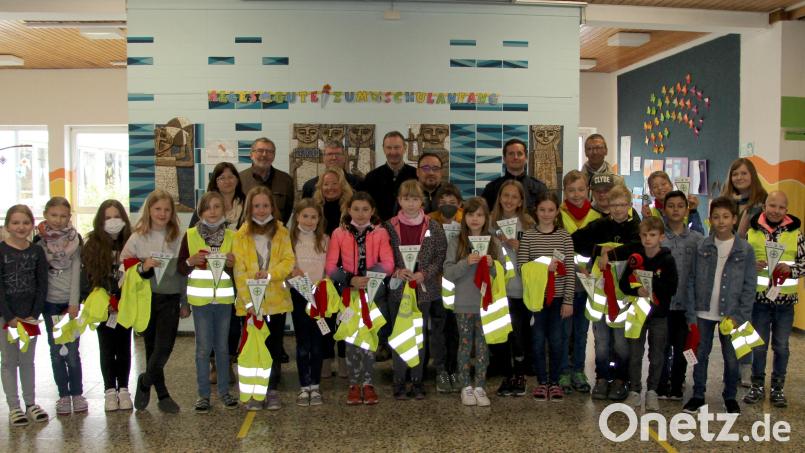 Die Mädchen und Buben der Vierten Klasse nach bestandener Prüfung im Kreis der Gratulanten: (hinten von links: Stefanie Bär vom Elternbeirat, Johann Gebhardt von der Verkehrswacht Sulzbach-Rosenberg, Michael Heinz von der Sparkasse Amberg-Sulzbach, davor Rektorin Birgit Molitor, Ralf Dittrich vom TÜV Sulzbach-Rosenberg, die Polizisten Markus Steinl und Philipp Böhme, Bürgermeister Peter Achatzi und Lehrerin Helene Spack. Bild: ds