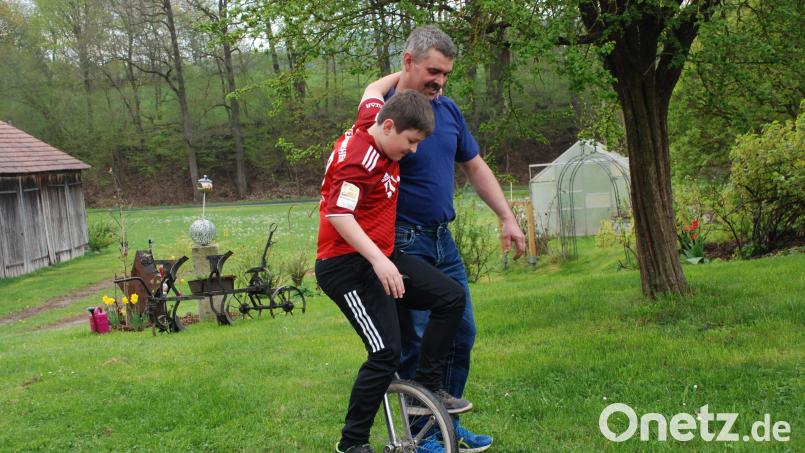 Aller Anfang ist schwer: Tobias Schiml, 12, nutzt die Gelegenheit, um das Einradfahren auszuprobieren. Eines ist klar: Am Anfang geht es nicht ohne Stütze. Papa Matthias hilft weiter. Bild: cvl