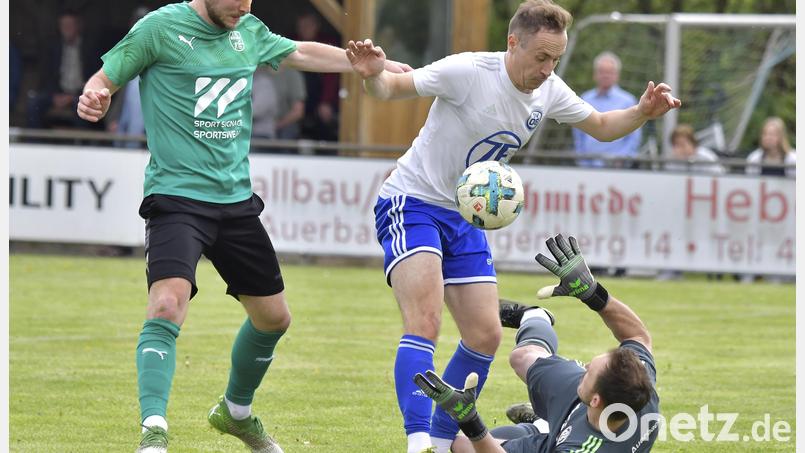 Brenzliche Situation im Auerbacher Strafraum: Spielertrainer Michael Keil (Mitte) schirmt den Ball vor seinem am Boden liegenden Torhüter Sebastian Kausler (rechts) ab, Maximilian Nimsch vom 1. FC Rieden (links) ist in Lauerstellung. Bild: Hubert Ziegler