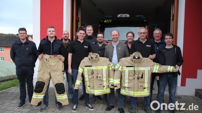 Ensdorfs Bürgermeister Hans Ram (Mitte) übergibt die neuen Schutzanzüge an die Vertreter der drei gemeindlichen Feuerwehren. Bild: tra
