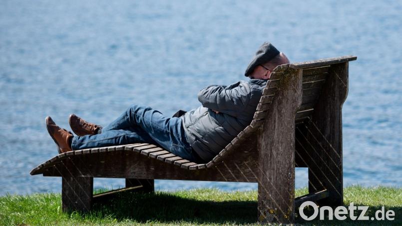 Ein Mann liegt am Ufer des Tegernsees in der Sonne. Bild: Sven Hoppe/dpa/Symbolbild