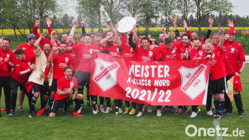 Mit spritzendem Sekt und der Meisterschale feierten die Spieler, Trainer und Verantwortliche der SV Michaelpoppenricht den Titel in der A-Klasse Nord und den Aufstieg in die Kreisklasse. Bild: hpr
