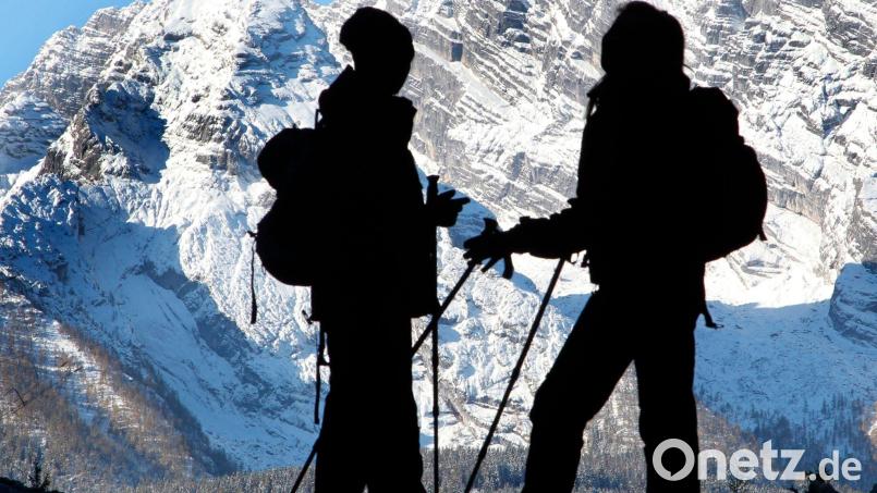 Ein Mann und eine Frau stehen im Berchtesgadener Land vor der Kulisse der Ostwand des Watzmann. Bild: picture alliance / dpa