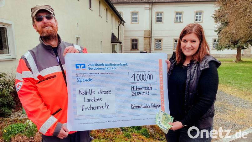 Fotografin Katharina Eckstein übergab in Fockenfeld an Wolfgang Rosner (links) vom BRK-Leitungsteam der Notunterkunft ihre 1000-Euro-Spende. Bild: BRK Kreisverband/exb