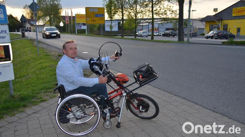 Markus Vogel zeigt als Rollstuhlfahrer die Schwierigkeiten bei der Überquerung der Weidener Straße in Speichersdorf. Dort soll ein barrierefreier Überweg zum Einkaufszentrum angelegt werden. Bild: ak