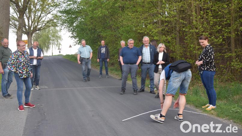 Bürgermeister Rudolf Schopper (stehend, Dritter von rechts) zeigt am Botzersreuther Berg Straßenschäden auf. Simon Schönberger legt schon mal den Meter an. Auf 800 Quadratmeter Sanierungsfläche würde man in etwa kommen. Bild: fz