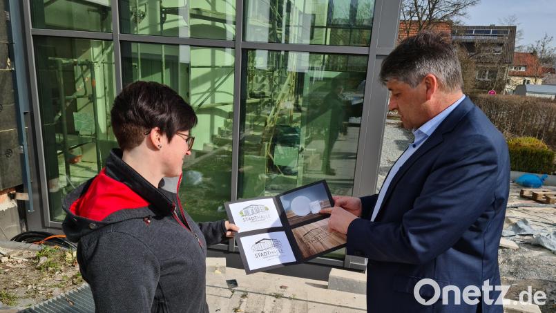 Designerin Verena Schuller zeigt Bürgermeister Edgar Knobloch verschiedene Verwendungszwecke für das Logo der Stadthalle. Bild: sne