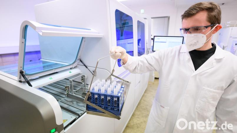 Ein Labormitarbeiter bestückt ein Gerät für die molekulare Diagnostik mit Patientenproben. Symbolbild: Julian Stratenschulte