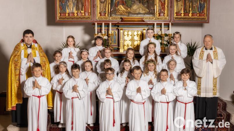 Die Kommunionkinder mit Stadtpfarrer Georg Flierl (rechts) und Kaplan Ramon Rodriguez (hinten links). Bild: Fotostudio Hummer