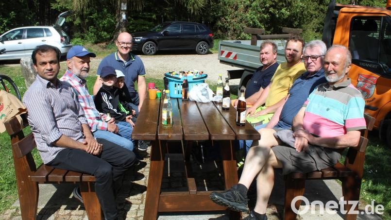 Pfarrer Pater Anish George (links) und Kirchenpfleger Stefan Kausler mit den fleißigen Helfern, die die neue Sitzgarnitur nach getaner Arbeit mit einer Brotzeit einweihten. Bild: soj