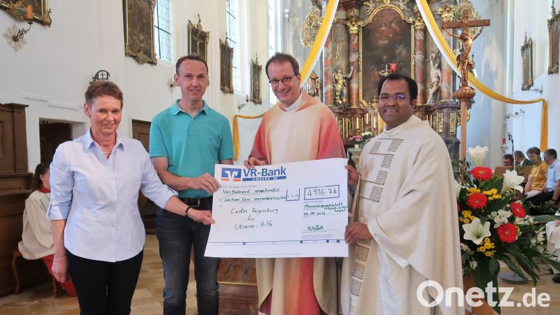 Einen Spendenscheck der Pfarreiengemeinschaft für die Ukraine-Hilfe übergeben (von links): Pfarrgemeinderatsvorsitzende Michaela Kreuzer, Kirchenpfleger Thomas Pröls, Domkapitular Michael Dreßel und Stadtpfarrer Pater Robin Xavier. Bild: rha