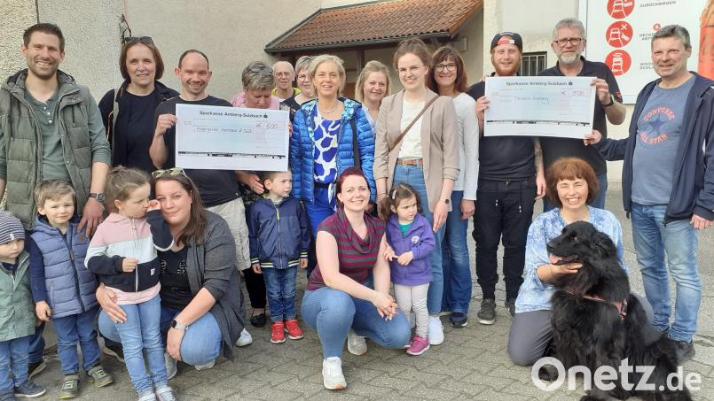 Gruppenbild mit Hund und Schecks: Spender und Empfänger des Erlöses aus dem Dart-Turnier in Hahnbach freuen sich gemeinsam. Bild: hka