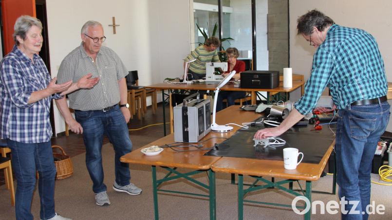Während Max Sturzer (rechts) sich dem defekten Radio-Recorder widmete, erledigte Ulrike Loos an der Nähmaschine Ausbesserungsarbeiten. Winfried Franz (Zweiter von links) regelte den geordneten Ablauf. Bild: ds