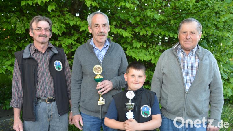 In der Jahreshauptversammlung der Kleintierzüchter kürt Vorsitzender Josef Faltenbacher (links) die Vereinsmeister aus den verschiedenen Sparten. Jungzüchter Mathias Später (vorne) erhielt einen Pokal für Bestnoten für seine Zwergwidder rhönfarbig. Bild: dob