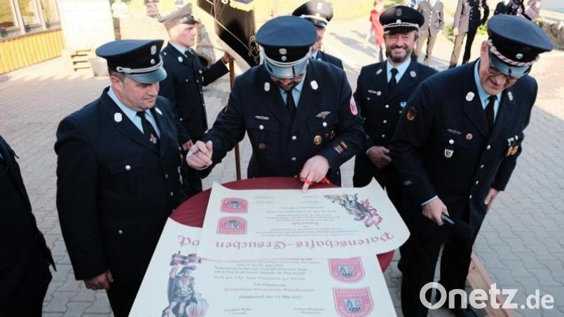 Die Vorsitzenden und die Kommandanten der Feuerwehren Glaubendorf und Oberköblitz unterzeichnen gemeinsam die Patenschafts-Urkunden. Bild: Thomas Klinger/exb
