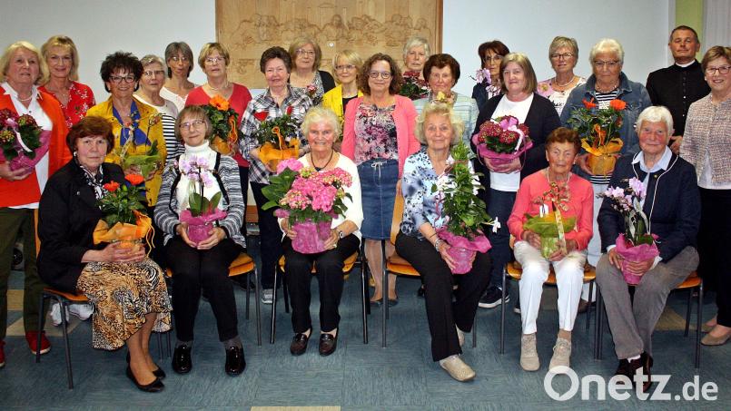 Vorsitzende Christine Hüttner (stehend, Mitte) zeichnet zahlreiche Frauen für ihre langjährige Mitgliedschaft beim Frauenbund St. Elisabeth aus. Auch Bezirksvorsitzende Margit Konze (rechts) gratuliert den Geehrten. Bild: R. Kreuzer