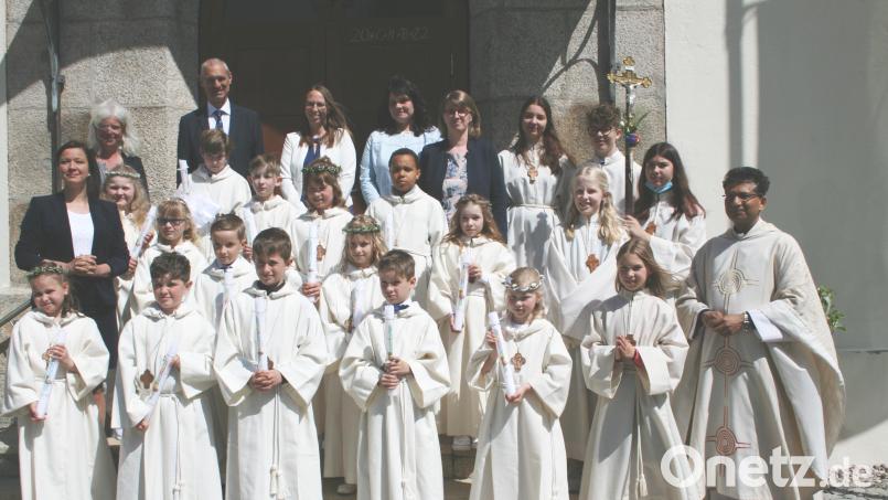 Die Friedenfelser Kommunionkinder mit Pfarrer Joseph (rechts mit den Ministranten), Religionslehrerin Dr. Elisabeth Hammer-Butzkamm (links) und Konrektor Stefan Müllbauer, Klassenlehrerin Claudia Wölke und Tischmutter Christine Schraml. Bild: roh