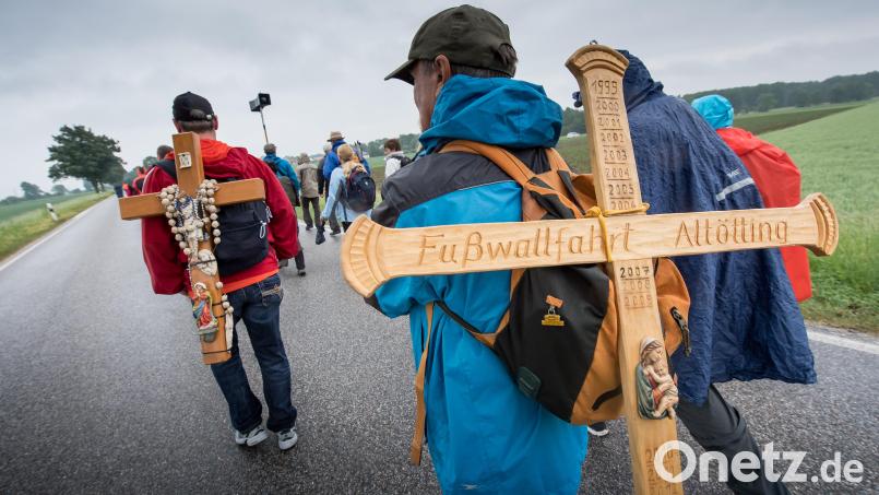 Pilger tragen während der Fußwallfahrt von Regensburg nach Altötting ein Holzkreuz auf dem Rücken. Bild: Peter Kneffel / dpa