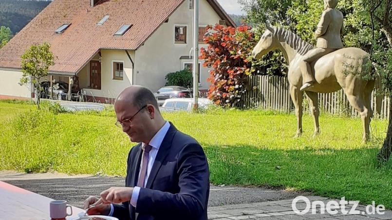 Albert Füracker in Etsdorf: Der bayerische Heimatminister beim Weißwurstfrühstück, während die ehemalige Kanzlerin Angela Merkel nur einen Steinwurf von ihm entfernt ist – jedoch nur als Reiterstatue. Bild: Sandra Preitschaft/exb