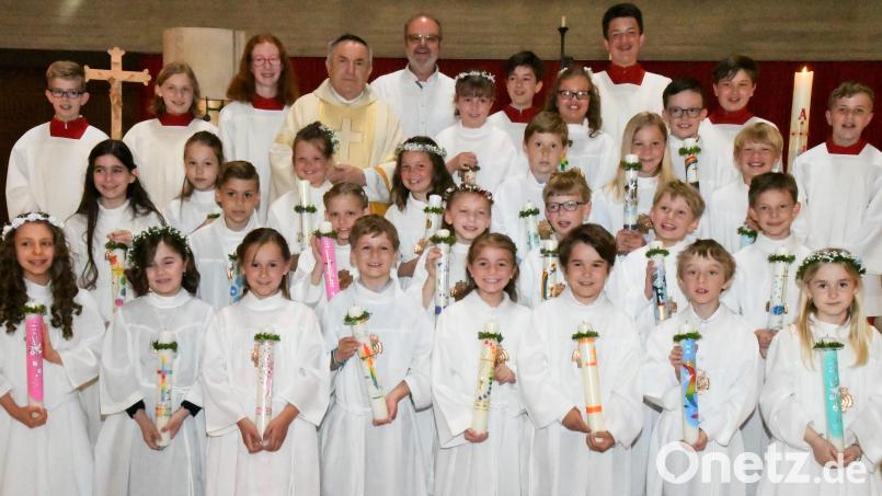 24 junge Christen der Pfarrgemeinde Aschach-Raigering durften zum ersten Mal die Kommunion empfangen . Hinten im Bild die Ministranten, Pfarrer Eduard Kroher und Gemeindereferent Anton Rauch. Bild: sche