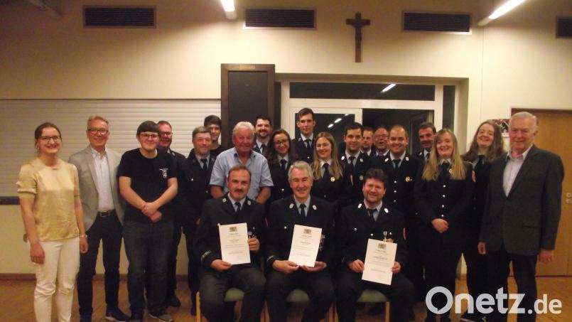 Die Muglhofer Feuerwehr zeichnet (sitzend, von links) Franz Voith, Rudi Kreis und Ludwig Zielbauer für 40 Jahre aktiven Feuerwehrdienst aus. Die neuen Kommandanten sind Markus Balk (Fünfter von rechts) und daneben Thomas Balk (Achter von rechts). Bild: ror