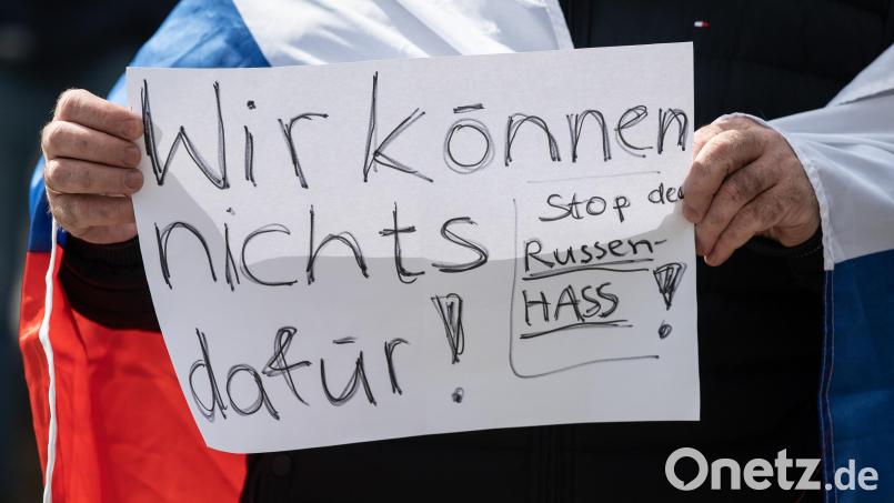 „Wir können nichts dafür - Stop den Russen-Hass“ steht auf dem Schild eines Mannes, der an einer prorussischen Kundgebung teilnimmt. Bild: Boris Roessler/dpa