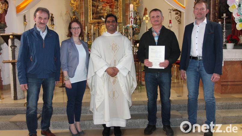 Mit einer Urkunde und einem Geschenk bedanken sich Pfarrer Pater John Subash Vincent (Mitte) und Bernhard Lang (rechts) bei Georg Sauer (Zweiter von rechts). Günter Götz war zur Verabschiedung verhindert. Bild: pi