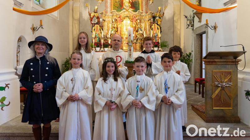 Die Kommunionkinder Helena Schmeller, Anna Schneider, Alexander Müller und Theo Müller (vorne, von links) mit ihrer Klassenlehrerin Rosa Maria Hammer (links) und Pfarrer Armin Maierhofer (Mitte). Bild: Pfarrei Mähring/exb