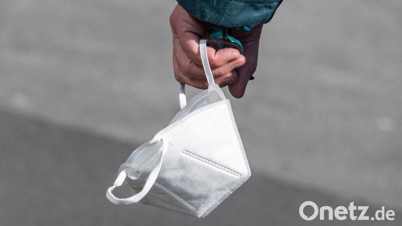 Ein Passant trägt eine FFP2-Maske in der Hand. Bild: Boris Roessler/dpa/Symbolbild