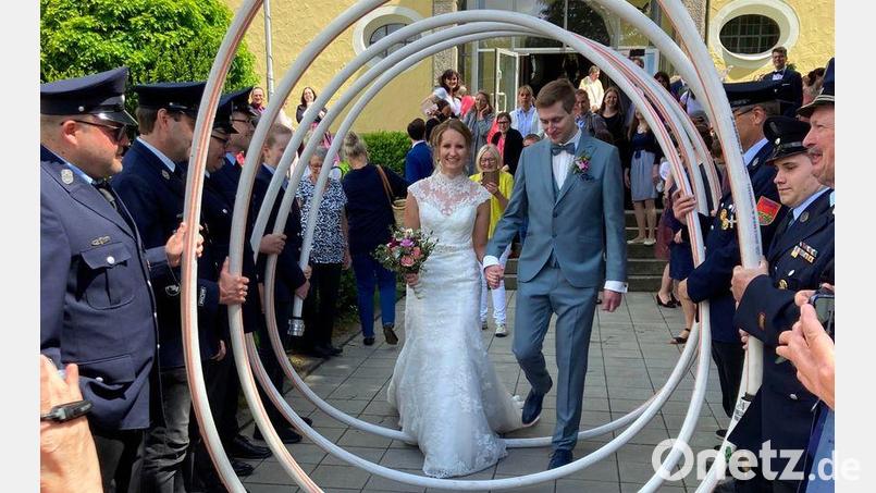 Sandra Neubeck-Weiser und Felix Weiser durchschreiten ein Schlauchspalier der Feuerwehr Plößberg. Bild: le