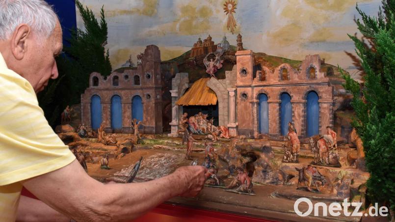 Alfred Mehler sucht die richtigen Plätze für die empfindlichen Papierfiguren. Der Verkäufer der Krippe, Peter Riolini, hat den Aufbau exakt vorgegeben. Für den Ankauf gewährte die Stadt den Krippenfreunden einen Zuschuss. Archivbild: tsp