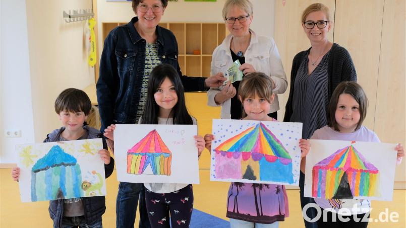 Frauenbundvorsitzende Elisabeth Nickl (li) und Vorstandsmitglied Melanie Reis (re) bei der Spendenübergabe an Rektorin Gabi Bodner. Einige Grundschulkinder freuen sich bereits auf die Zirkuswoche und zeigen ihre "Kunstwerke" Bild: do