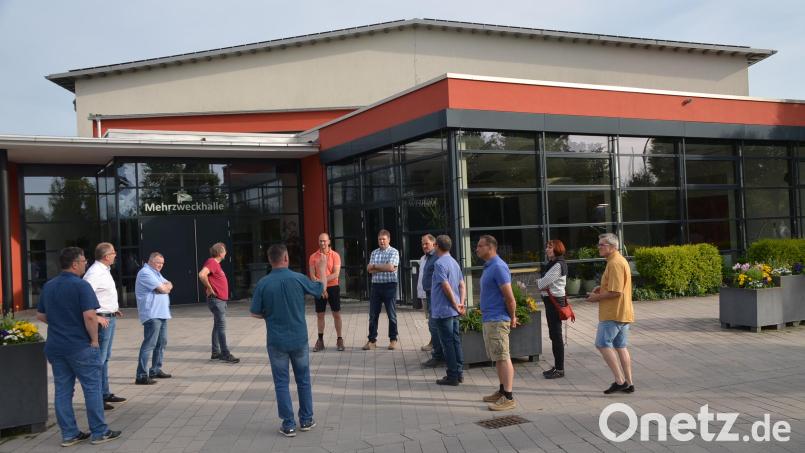Der Bauausschuss um Bürgermeister Roman Schäffler (Zweiter von links) sprach mit Vertretern des Bauamtes über Maßnahmen, um das Flachdach des Foyers der Mehrzweckhalle (Hintergrund) wieder dicht zu bekommen Bild: ak