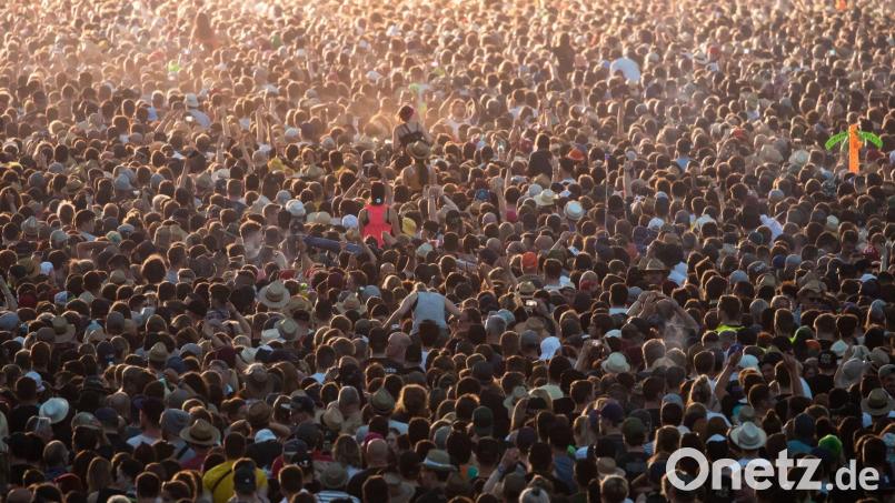 Zahlreiche Besucher des Open-Air-Festivals "Rock im Park" im Jahr 2019 stehen vor einer Bühne. Bild: Daniel Karmann/dpa/Archivbild
