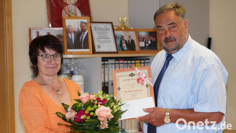 Bürgermeister Josef Beimler übergibt an Sieglinde Zielbauer Urkunde und Blumenstrauß zum 25-jährigen Dienstjubiläum. Bild: fvo