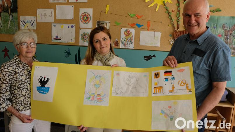 Stolz zeigt die Leiterin der ersten Willkommensklasse, Anahit Baloyan (Mitte), Rektor Herbert Kraus (rechts) und Eli Dreßler (links) die kleinen Kunstwerke der ukrainischen Schülerinnen und Schüler. Bild: le