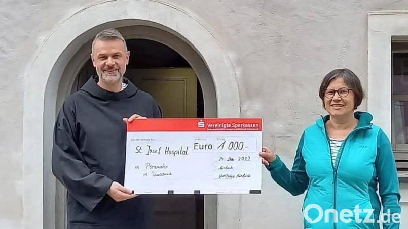 Bruder Samuel von den Missionsbenediktinern aus Münsterschwarzach und Christine Nickl-Dötsch mit dem symbolischen Scheck. Bild: Martina Heberl, Weltladen Auerbach/exb
