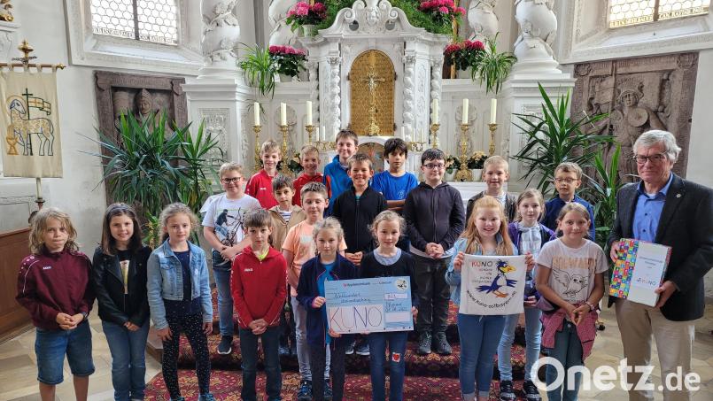 Professor Hugo Segerer (rechts) konnte in der Pfreimder Pfarrkirche von den Kommunionkindern eine Spende in Höhe von 863 Euro für Kuno entgegennehmen. Bild: hir