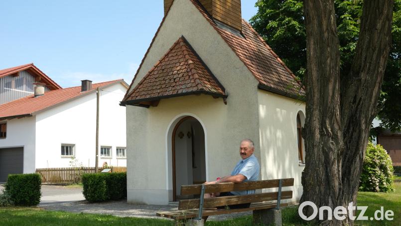 Der Vorsitzende des "Kapellenvereins Wohlfest", Johann Hermann, nimmt gerne Platz auf dem Bankerl vor der Marienkapelle. Seit 25 Jahren kümmert er sich um den Erhalt des Kirchleins und um die Pflege der Außenanlagen. Bild: Hirsch