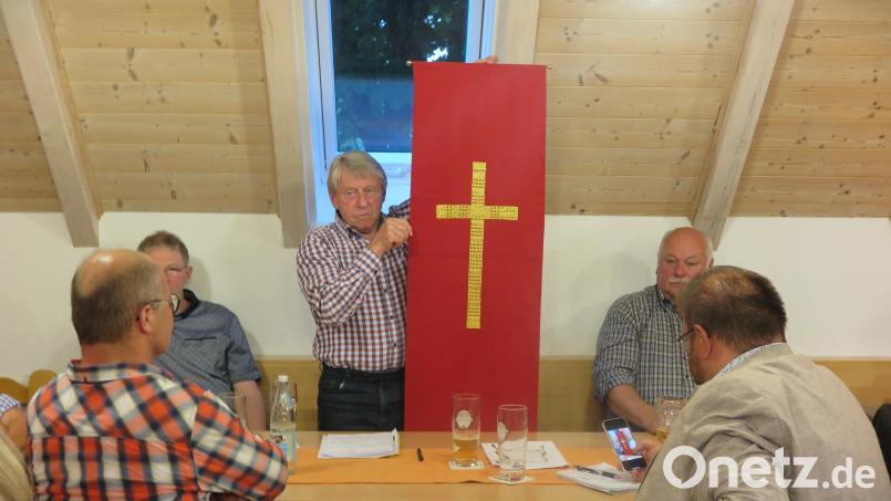 In der Jahreshauptversammlung zeigte Adolf Legath den Mitgliedern des Kapellenbauvereins Reuth den neuen Behang für das Rednerpult. Bild: jzk